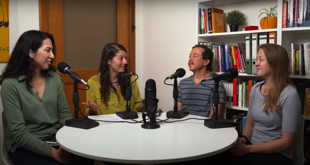 ERG professor and graduate students gathered around a table for discussion, with microphones for YouTube recording.