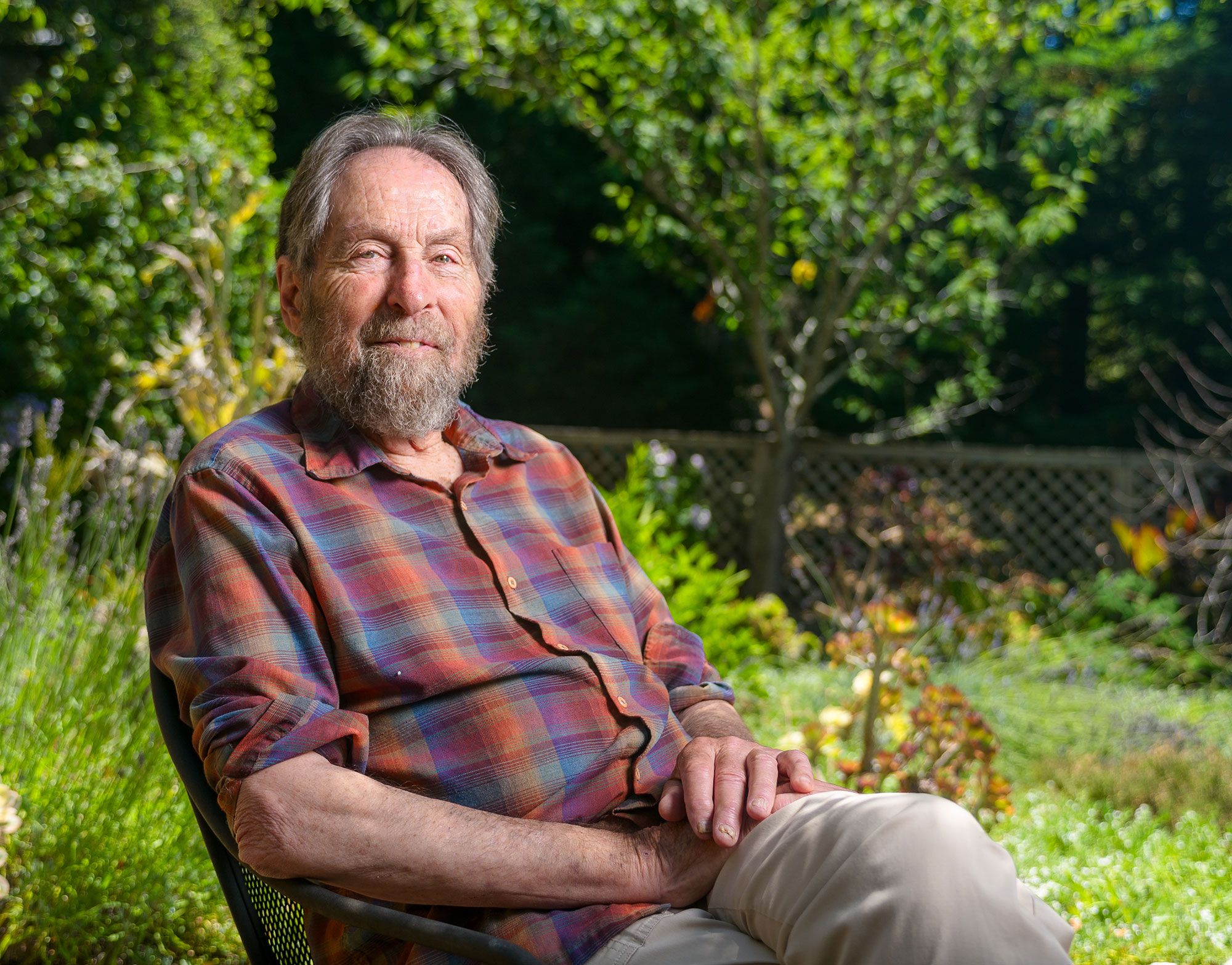 A man sitting calmly on a bench in a natural setting